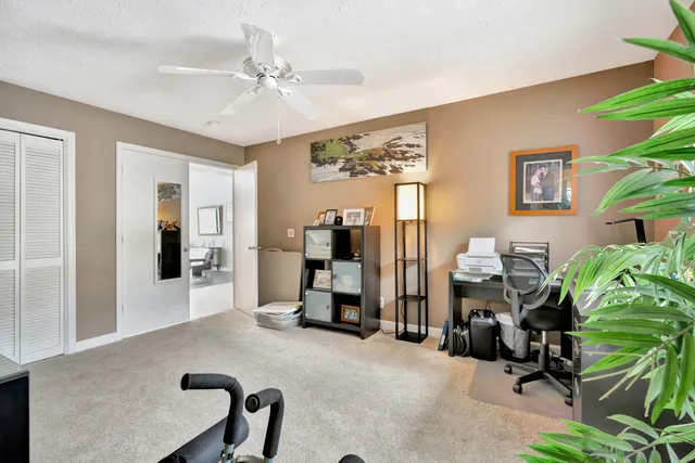 a view of a workspace with furniture and a ceiling fan