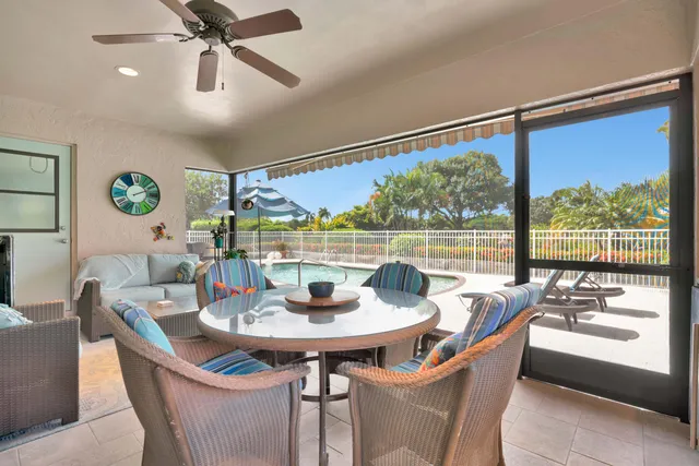 a dining room with furniture a rug and a floor to ceiling window