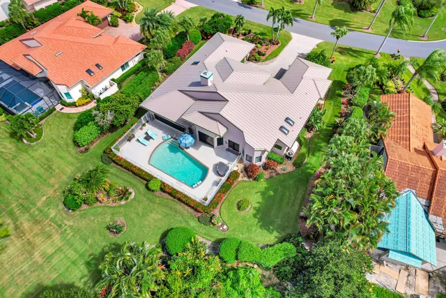 an aerial view of a house with garden space and trees all around