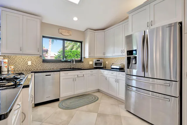 a kitchen with stainless steel appliances granite countertop a refrigerator sink and stove