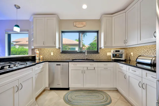 a kitchen with stainless steel appliances a sink a stove a window cabinets and a counter space