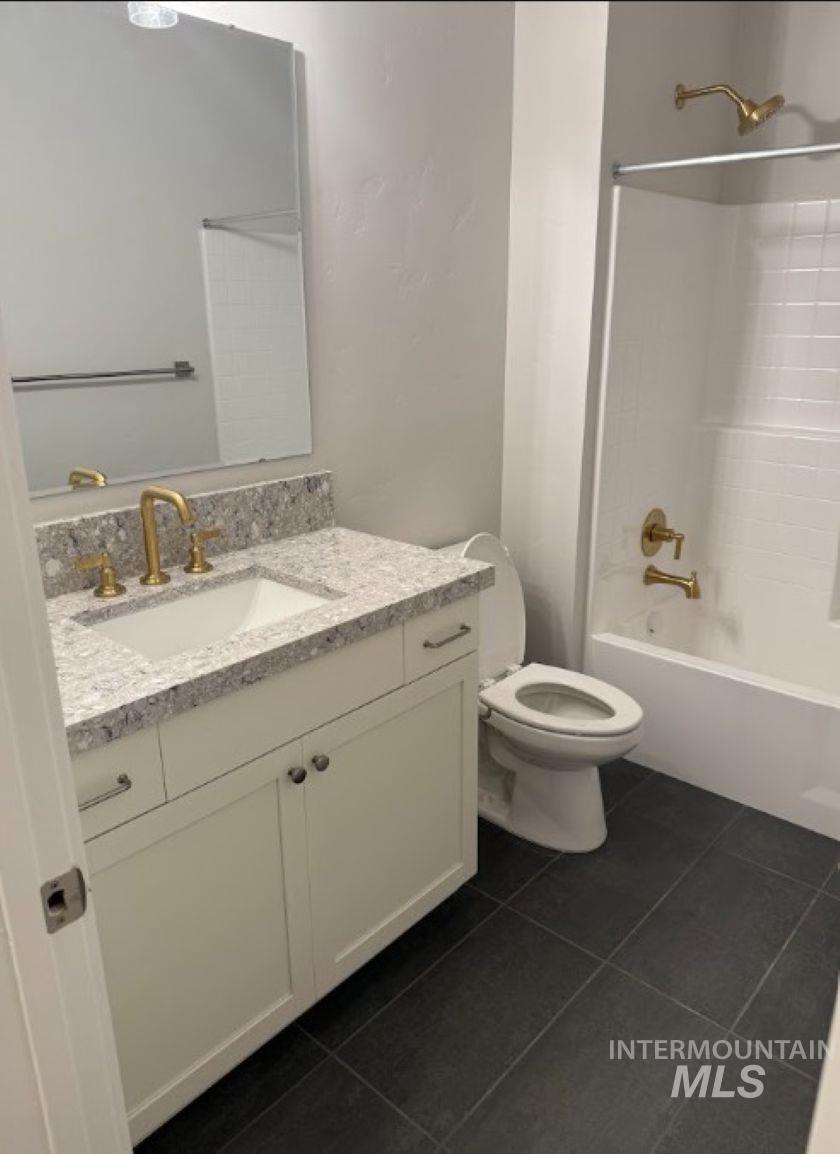 665 West Wrangler Street Meridian, ID 83646 - Photo 11 of 18 Bathroom featuring a light-toned vanity with a stone countertop, an undermount sink, and brass fixtures