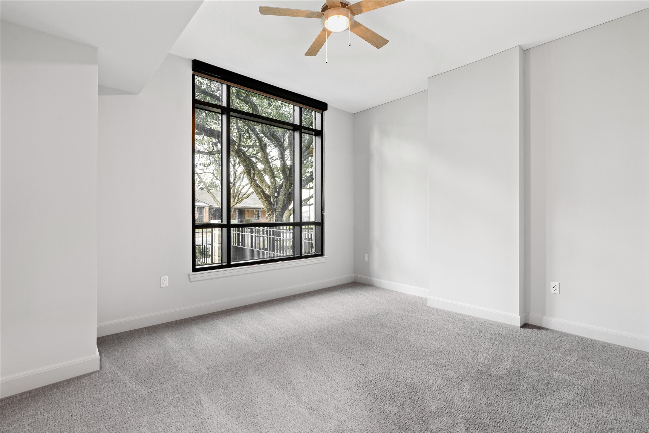 2511 Willowick Road, Unit 117 Houston, TX 77027 - Photo 15 of 43 an empty room with chandelier fan and windows