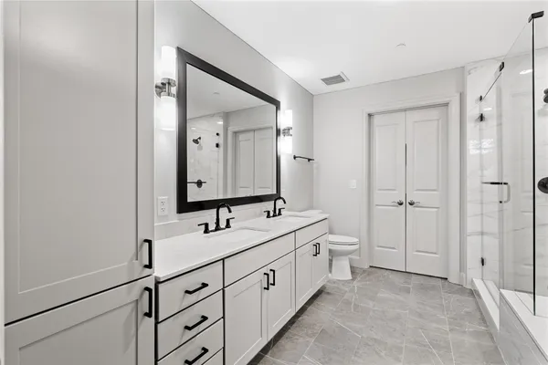 a spacious bathroom with 2 sink and a mirror