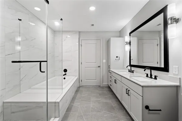 a bathroom with a double vanity sink and mirror with shower