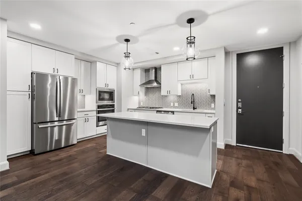 a kitchen with kitchen island white cabinets and stainless steel appliances