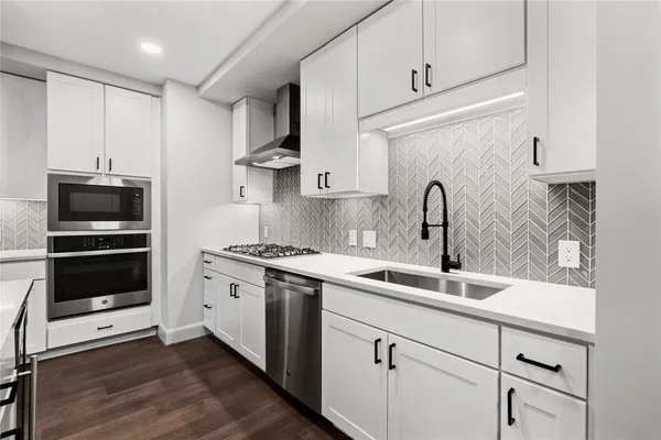 a kitchen with stainless steel appliances granite countertop a sink stove and refrigerator
