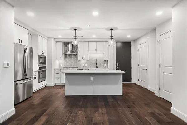 a kitchen with granite countertop a refrigerator and a sink