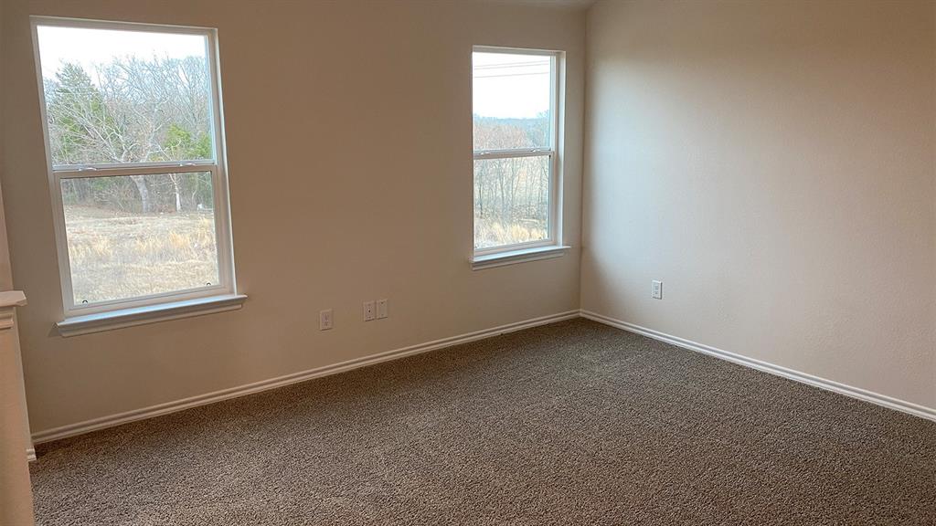 107 Hunters Way Canton, TX 75103 - Photo 14 of 23 Empty room with dark colored carpet and baseboards