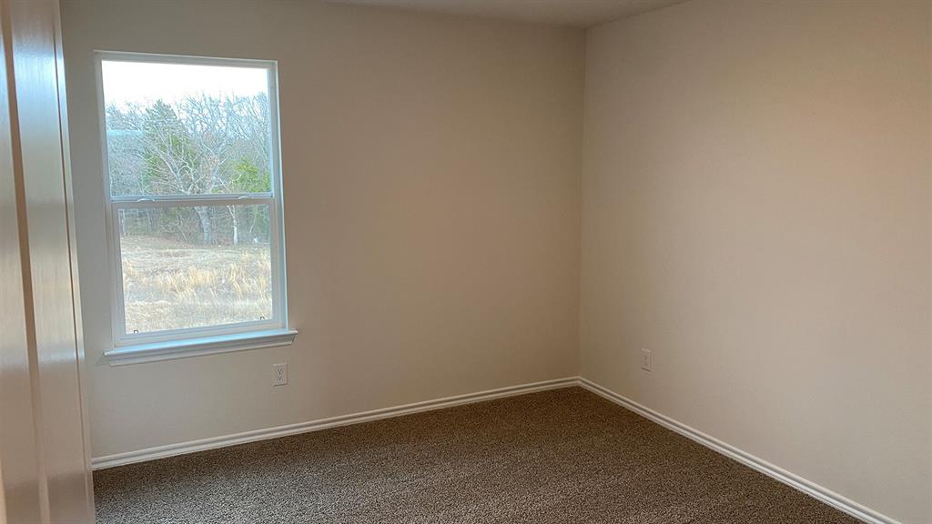 107 Hunters Way Canton, TX 75103 - Photo 16 of 23 Empty room with dark colored carpet and baseboards