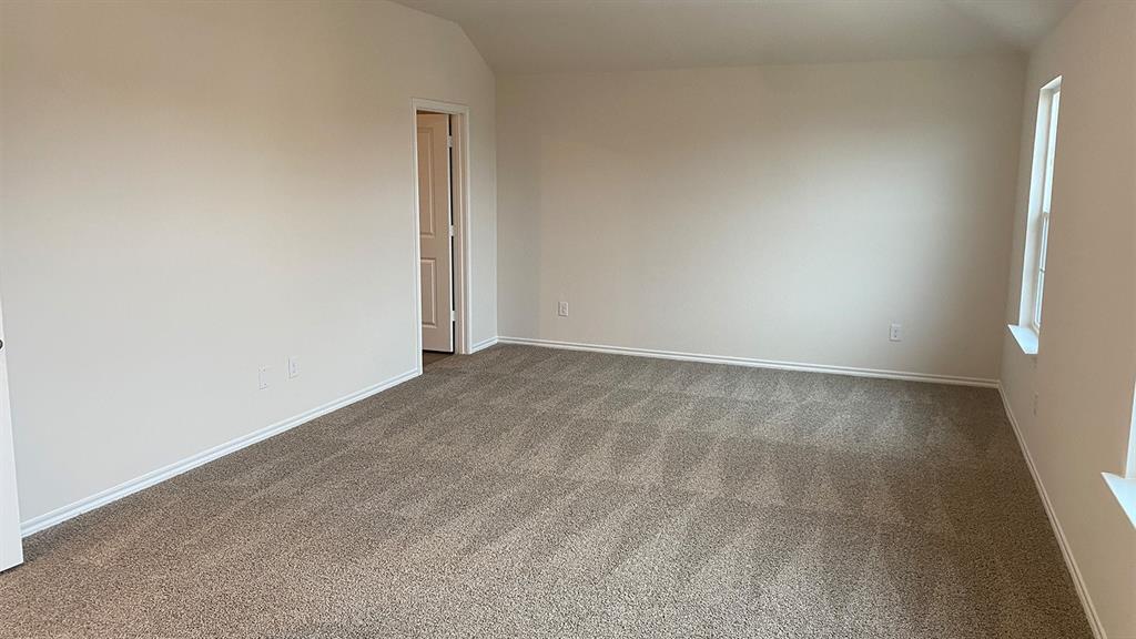 107 Hunters Way Canton, TX 75103 - Photo 19 of 23 Empty room featuring vaulted ceiling and dark colored carpet