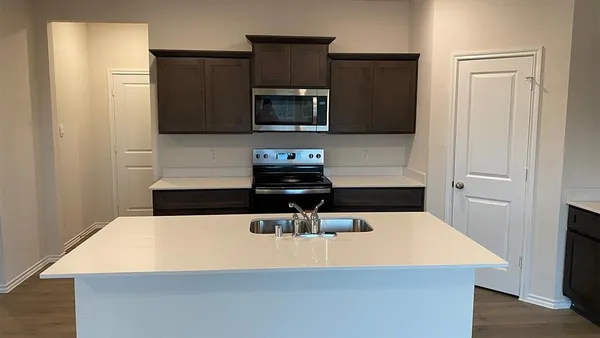 a kitchen with stainless steel appliances a stove microwave and sink