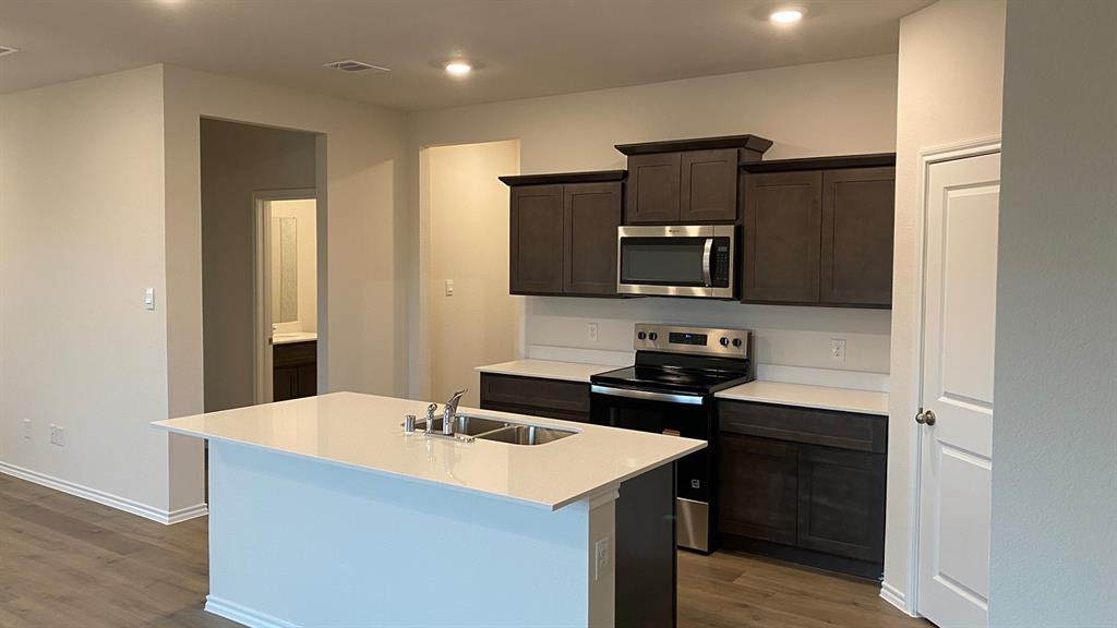 107 Hunters Way Canton, TX 75103 - Photo 23 of 23 Kitchen featuring stainless steel appliances, dark wood finish cabinets, a center island with sink, dark wood finished floors, and recessed lighting