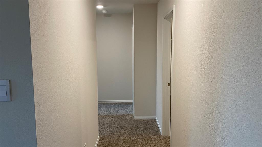 107 Hunters Way Canton, TX 75103 - Photo 5 of 23 Hallway with dark colored carpet and a textured wall