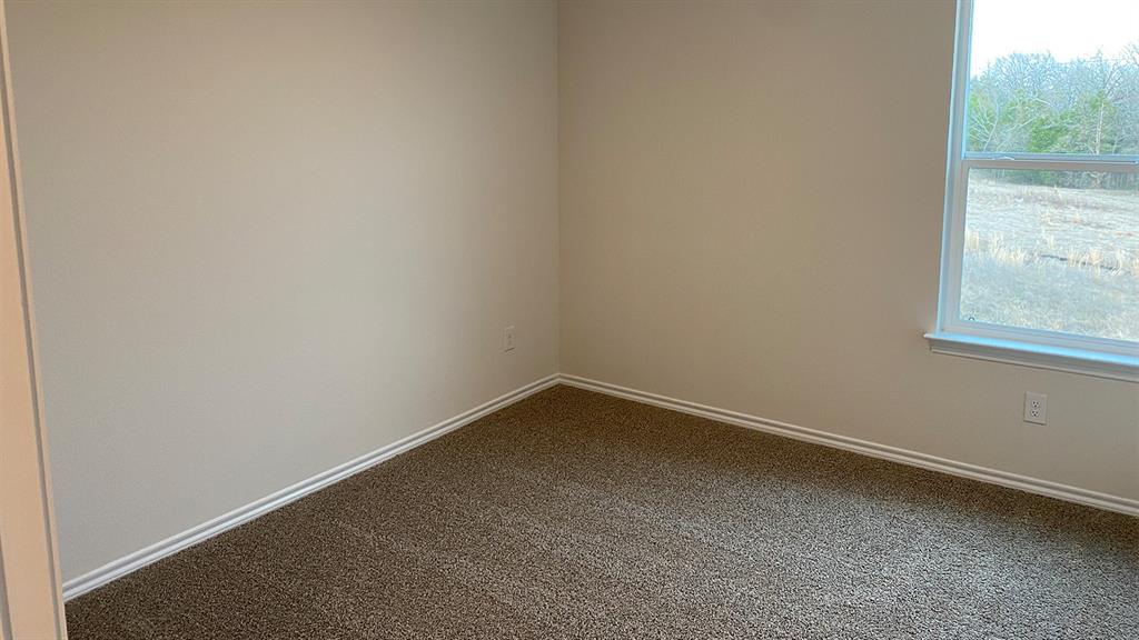 107 Hunters Way Canton, TX 75103 - Photo 9 of 23 Spare room with healthy amount of natural light and dark colored carpet