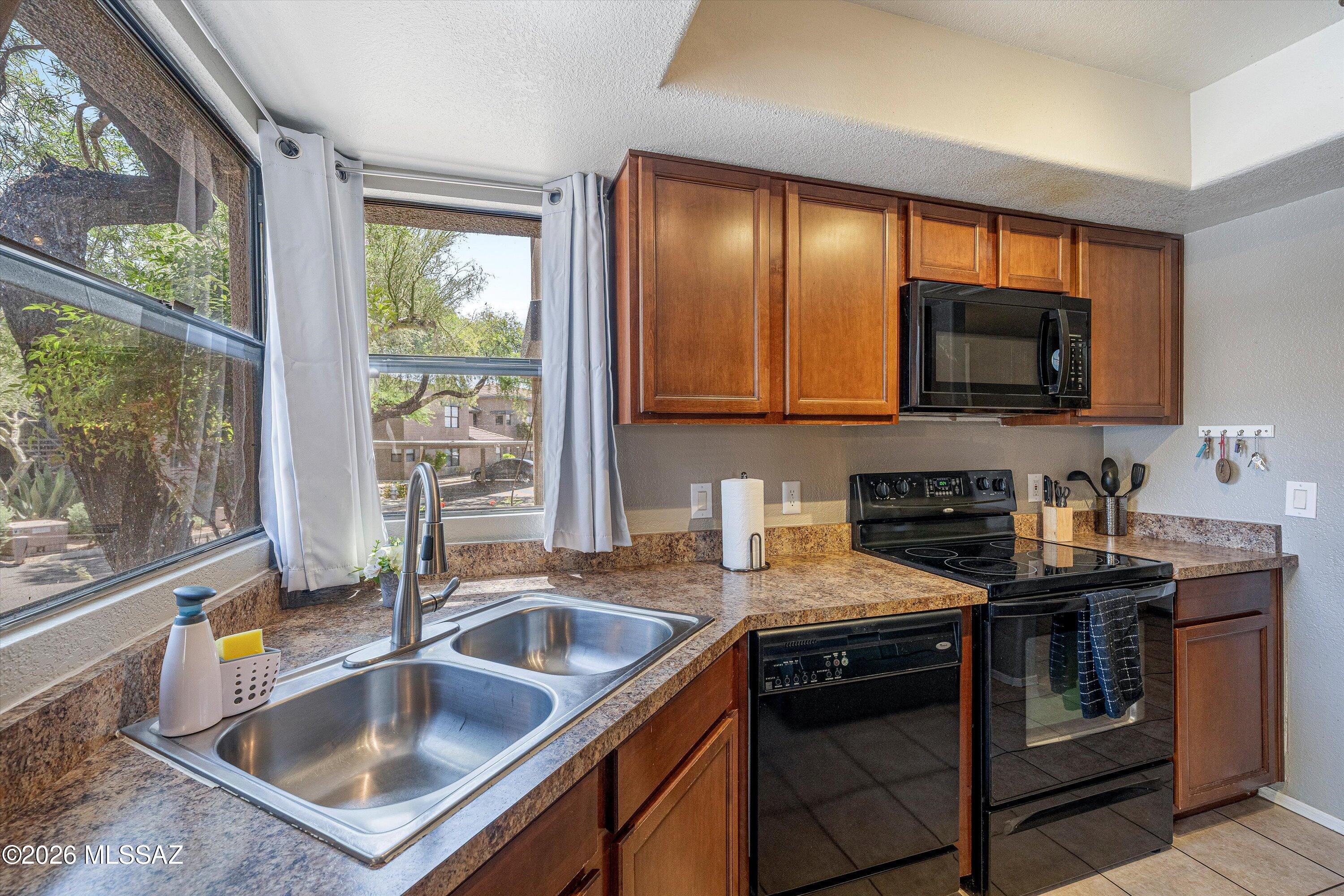 5855 North Kolb Road, Unit 8106 Tucson, AZ 85750 - Photo 7 of 34 a kitchen with kitchen island granite countertop a sink stove top oven and granite counter top