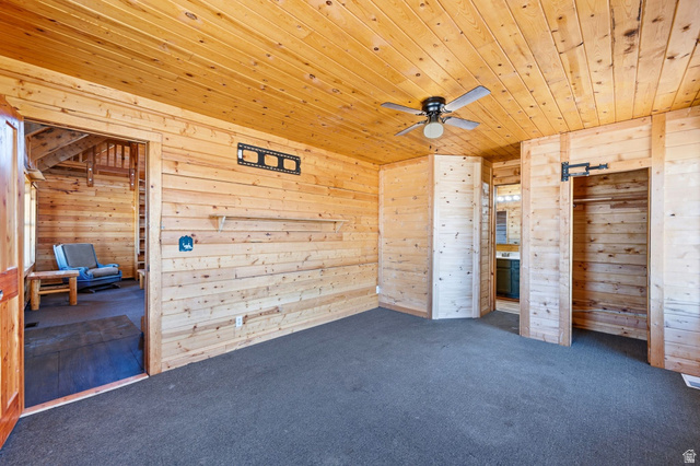10937 South County Road, Unit 29 Duchesne, UT 84021 - Photo 13 of 41 Wood-paneled room featuring a ceiling fan, wall-mounted shelving, and built-in closet space