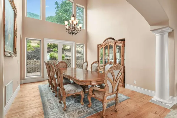 a view of a dining room with furniture a chandelier and wooden floor