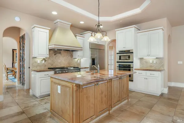 a kitchen with stainless steel appliances granite countertop a sink a stove and a refrigerator