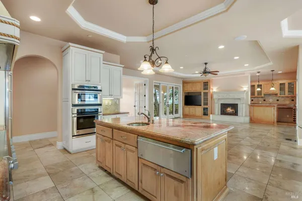 a kitchen with kitchen island granite countertop a stove and a sink with granite countertops