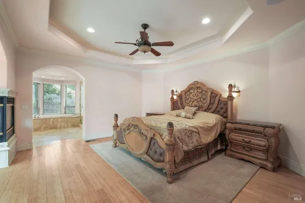 a spacious bedroom with a bed a chandelier and a window
