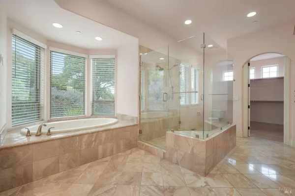a bathroom with a large tub shower and sink