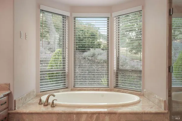 a bathroom with bathtub and window