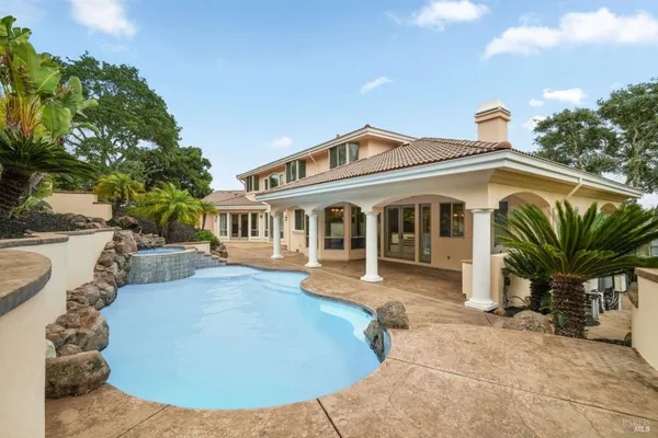 a view of a house with backyard and sitting area