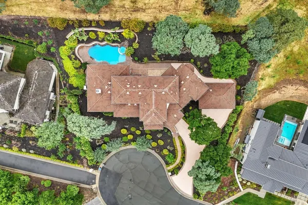 an aerial view of a house with a yard and black swimming pool