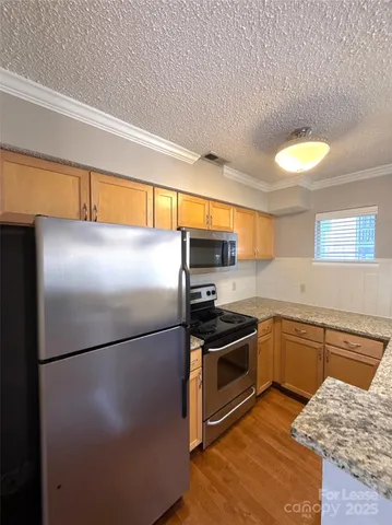 a kitchen with stainless steel appliances granite countertop a refrigerator a sink a stove and island