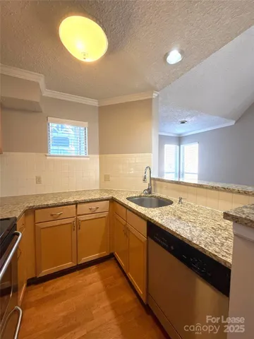 a kitchen with granite countertop sink stove and cabinets