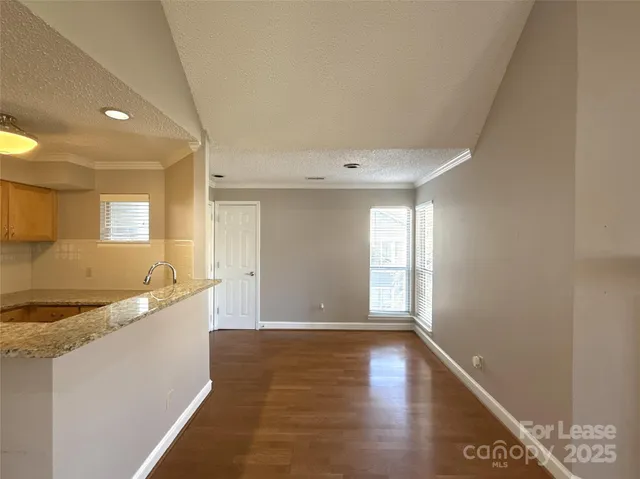 a large kitchen with lot of cabinets and wooden floor