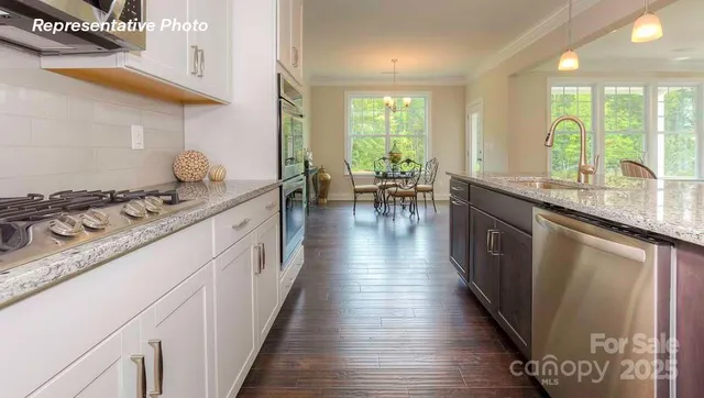 a kitchen with stainless steel appliances granite countertop a stove and a wooden floors