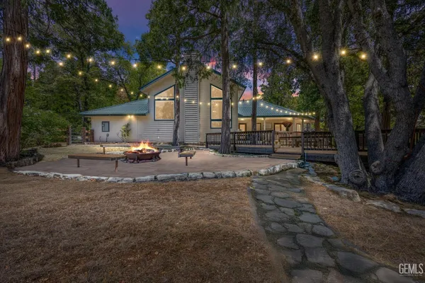 a dining room with wooden floor a chandelier a wooden table and chairs