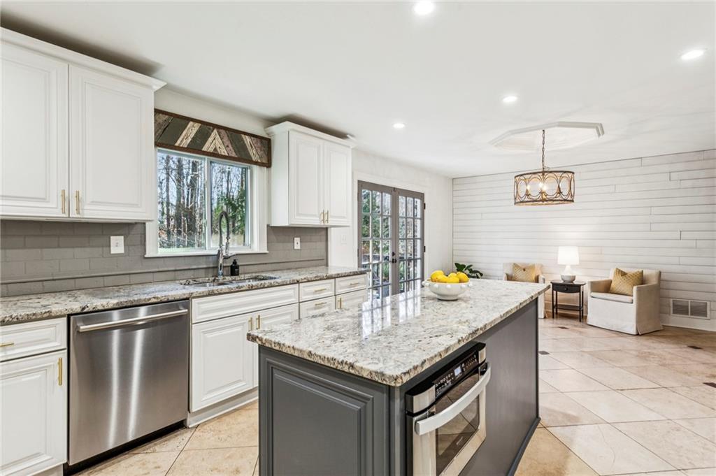 23 Midway Road Marietta, GA 30064 - Photo 11 of 32 a kitchen with stainless steel appliances granite countertop a stove a chimney a sink and cabinets