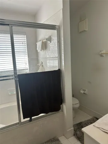 a bathroom with a sink a toilet a window and vanity