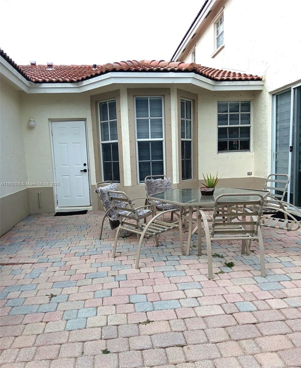 18730 Southwest 25th Court, Unit 18730 Miramar, FL 33029 - Photo 26 of 30 a backyard of a house with table and chairs