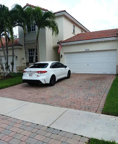 a car parked in front of white house