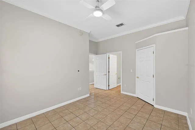 an empty room with windows and fan