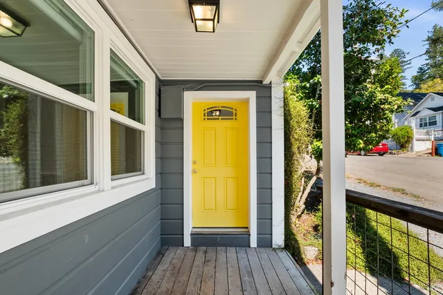 a view of a porch with wooden floor and front door
