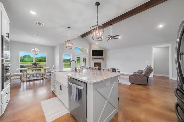 a view of living room with kitchen island furniture and flat screen tv