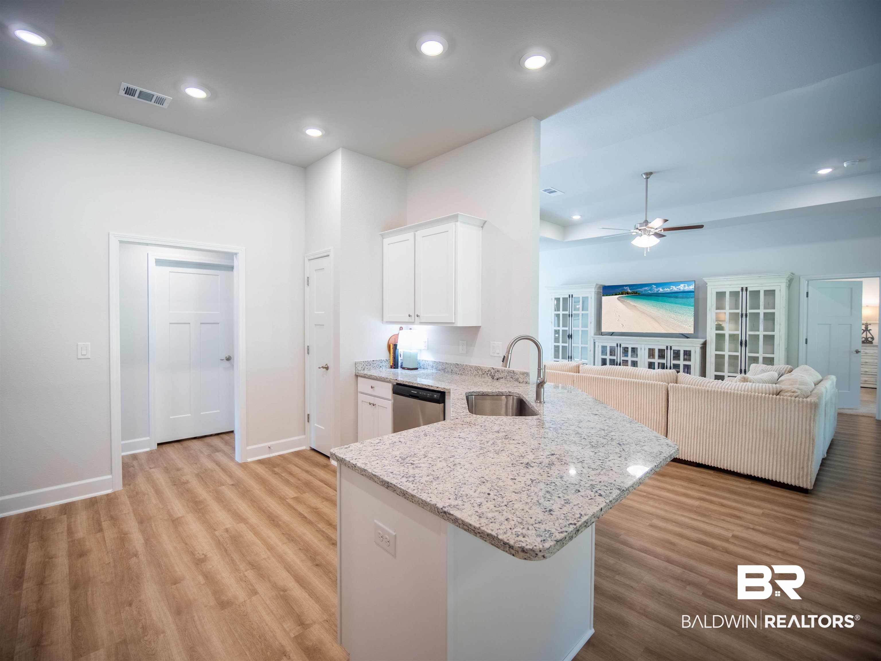 12646 Michigan Avenue Elberta, AL 36530 - Photo 10 of 47 Kitchen featuring stainless steel dishwasher, light wood-style flooring, ceiling fan, white cabinetry, and light stone countertops