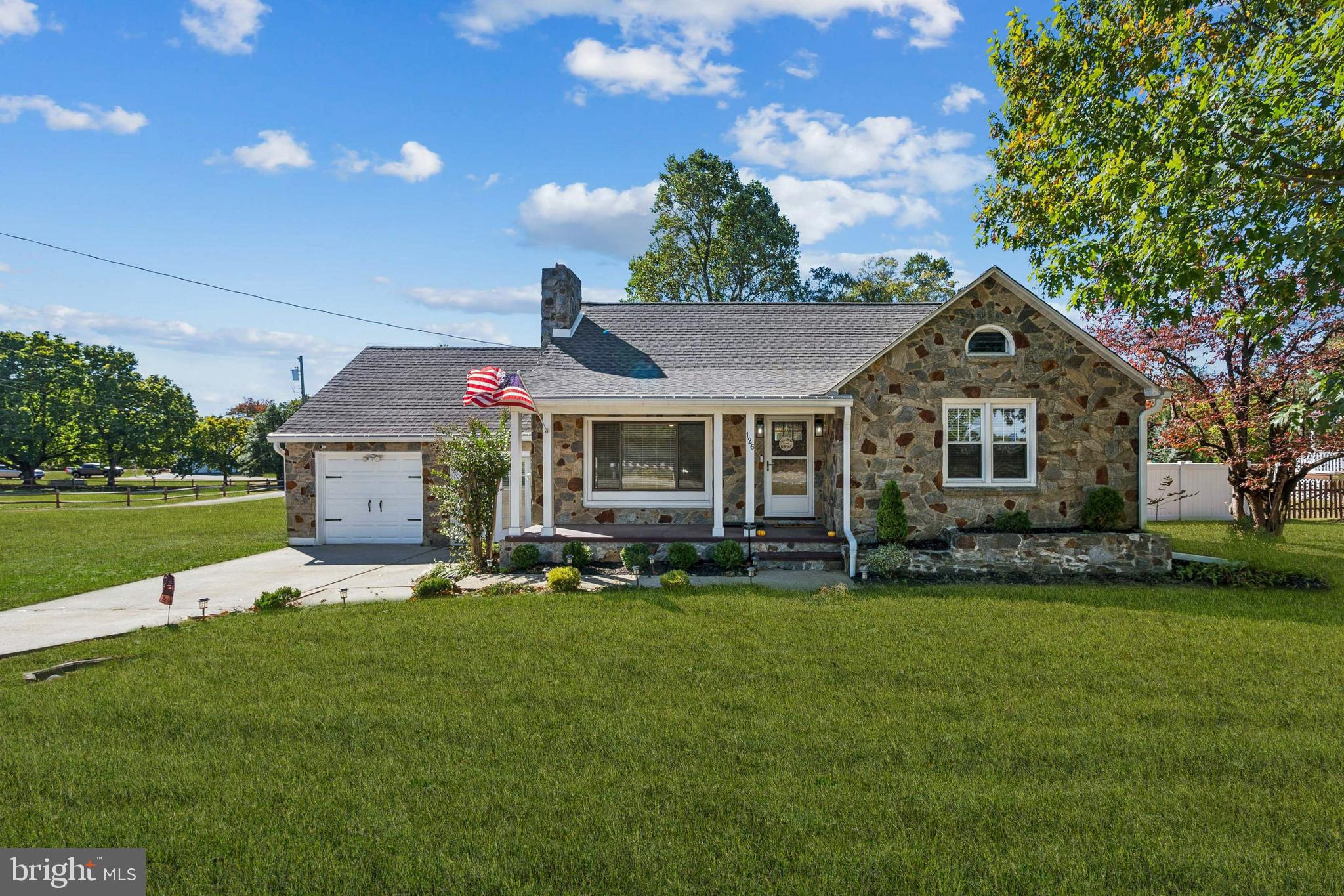 a front view of a house with a garden and yard