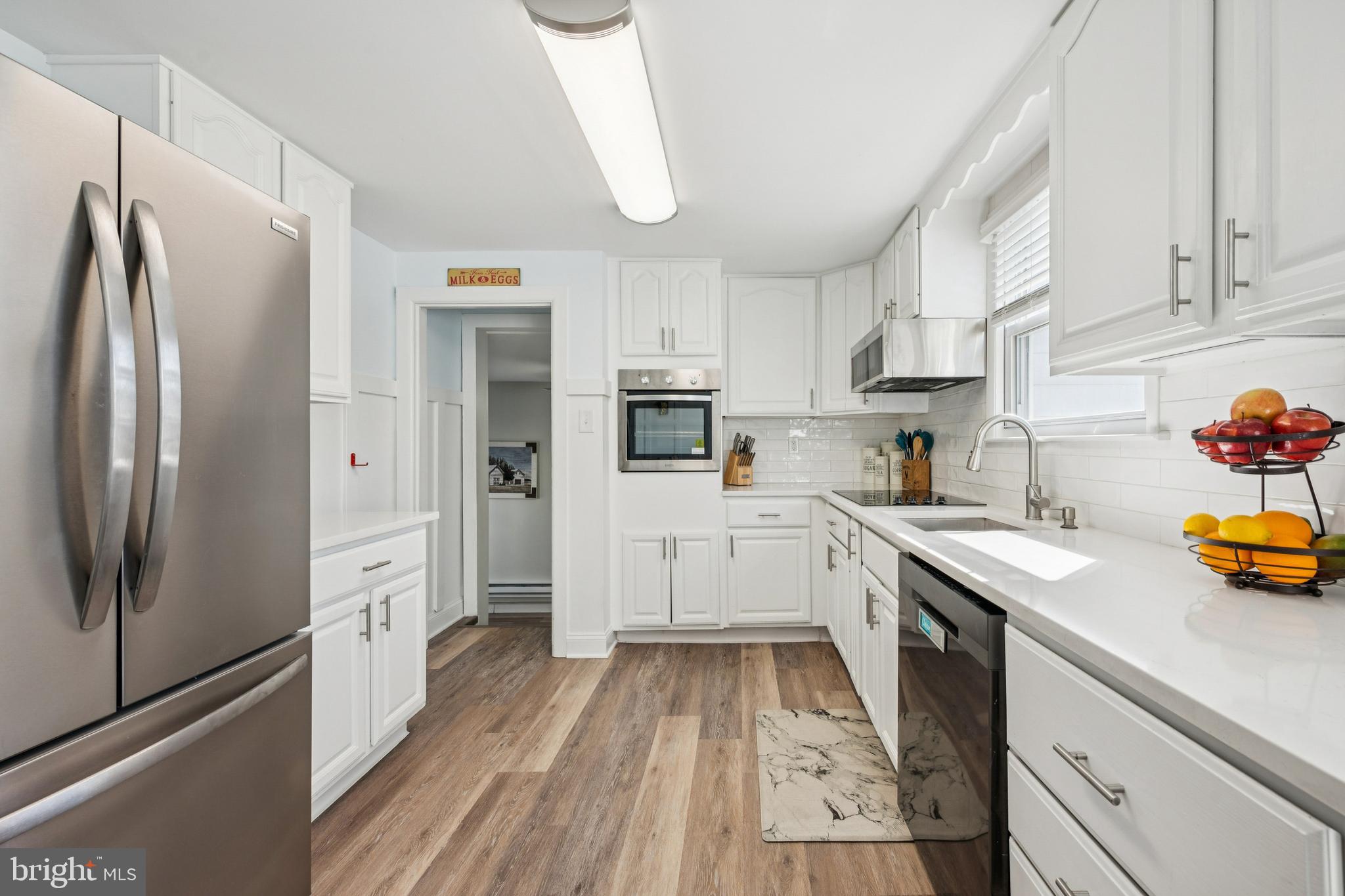126 Repaupo Station Road Swedesboro, NJ 08085 - Photo 2 of 25 a kitchen with a sink a refrigerator and cabinets