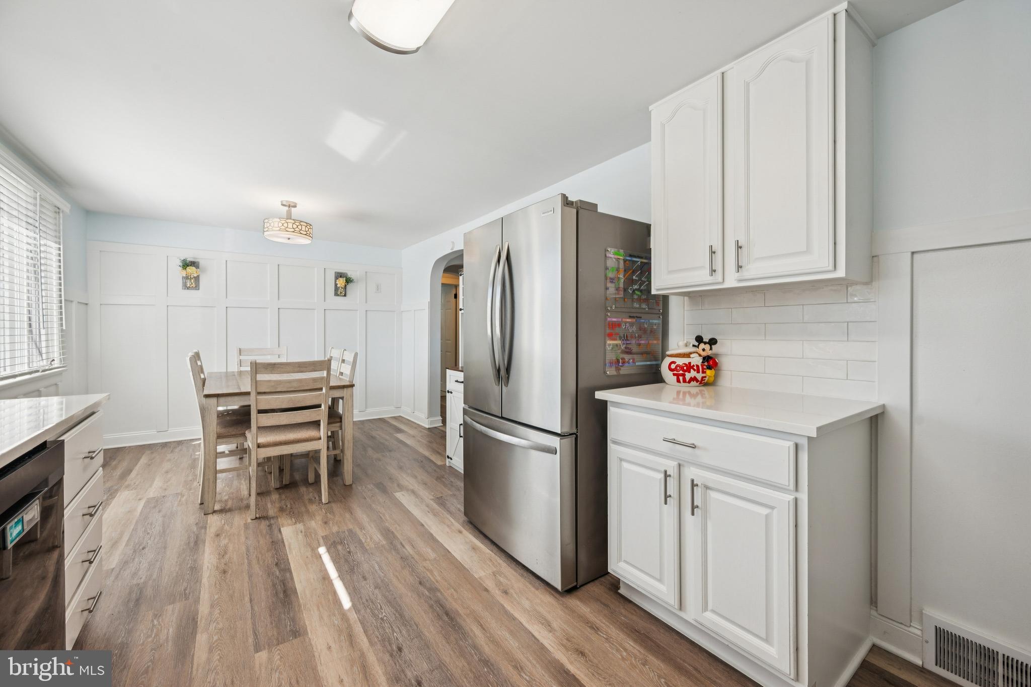 126 Repaupo Station Road Swedesboro, NJ 08085 - Photo 4 of 25 a kitchen with stainless steel appliances a refrigerator a stove a sink dishwasher and white cabinets with wooden floor