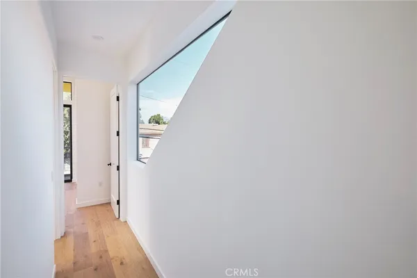 a living room with a large window and a wooden floor