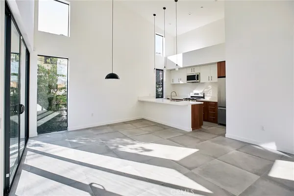 a view of a kitchen with kitchen island a sink stainless steel appliances and cabinets