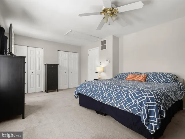 a bed sitting in a spacious bedroom next to a window and a chandelier