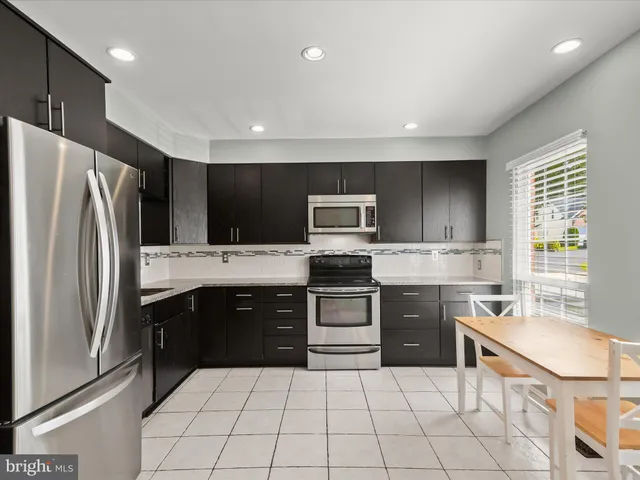 a kitchen with a sink a stove a refrigerator and cabinets