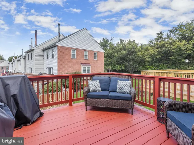 a balcony of a house with wooden floor and outdoor seating